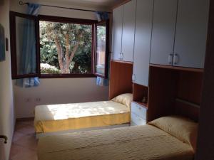 Un dormitorio con dos camas y una ventana. en Villetta Rena Majore, en Rena Majore 16 fotos más