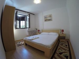 a small bedroom with a bed and a window at Apartment Kotor-Andrija Jovanovic in Kotor