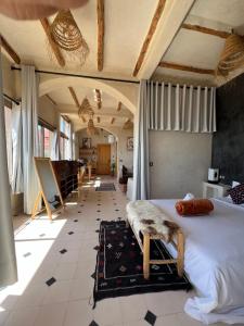 a bedroom with a large bed and a large window at SurfAppart Morocco in Tamraght Ouzdar