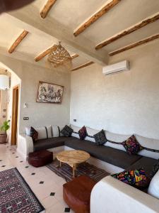 a living room with a couch and a table at SurfAppart Morocco in Tamraght Ouzdar +37 photos