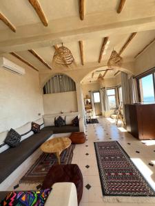 a living room with a couch and a table at SurfAppart Morocco in Tamraght Ouzdar