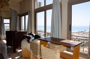 two birds sitting on a table in a room with a balcony at SurfAppart Morocco in Tamraght Ouzdar