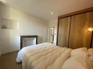 a bedroom with a large bed with a wooden headboard at Appartement Centre ville Historique in Bayeux