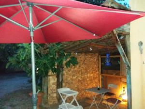 a red umbrella and a table and a chair at Apartment Albert parking privé gratuit in Limoux