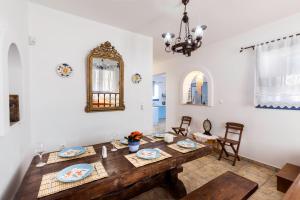 una sala da pranzo con tavolo in legno e specchio di Villa Elias a Archangelos