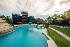 a swimming pool with blue chairs and some buildings at X'tan Ha- The Waterfront in San Pedro