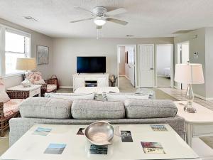 a living room with a couch and a tv at Latitude Adjustment A in Tybee Island