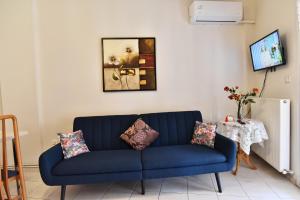 Un sofá azul con almohadas en una sala de estar. en KAVALA The Blue City, en Kavala