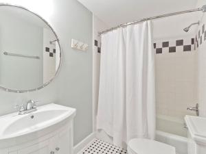 a white bathroom with a sink and a mirror at Habersham 2 in Savannah +24 photos