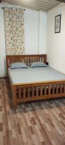 a bedroom with a wooden bed in a room at Sharia homestay in Kodaikānāl