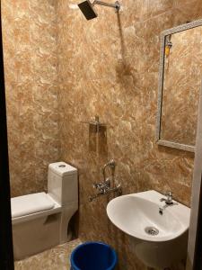 a bathroom with a sink and a toilet and a mirror at Sharia homestay in Kodaikānāl