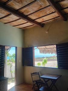 a room with a table and chairs and a large window at Casa Zion Land in Canoa Quebrada