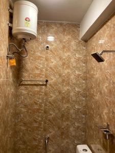 a bathroom with a toilet and a light on the wall at Sharia homestay in Kodaikānāl