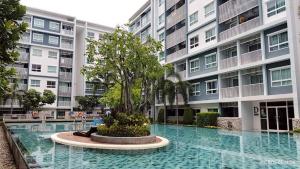 a building with a tree in the middle of a pool at The Condo Hua Hin by yadaphi in Hua Hin