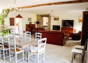 a dining room and living room with a table and chairs at Gîte chezmadlou in Colondannes