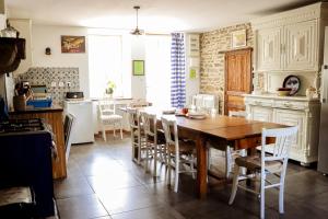 a kitchen with a wooden table and chairs in it at Gîte chezmadlou in Colondannes