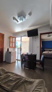 a room with a bedroom with a bed and a television at Hotel Los Lapachos in Puerto Iguazú