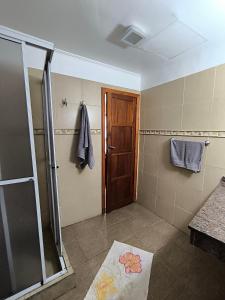 a bathroom with a shower and a glass door at Hotel Los Lapachos in Puerto Iguazú