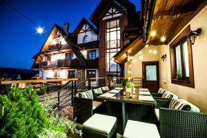 an outdoor patio with a table and chairs at Hotel Zawrat - KROK NA STOK! in Białka Tatrzanska