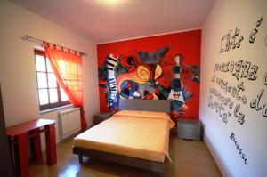 1 dormitorio con 1 cama con una pintura en la pared en La Dimora Degli Artisti, en Catanzaro