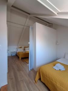 a bedroom with a yellow bed and a room at River & Beach Apartment near Lisbon in Trafaria +14 photos