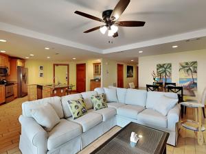 sala de estar con sofá blanco y ventilador de techo en Tybee Beach Club 137, en Tybee Island