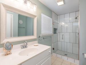 a bathroom with a sink and a shower with a mirror at The Flying Pigs Cottage in Tybee Island +32 photos