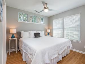a bedroom with a large white bed with two lamps at The Flying Pigs Cottage in Tybee Island
