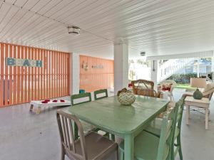 a green table and chairs in a living room at The Flying Pigs Cottage in Tybee Island
