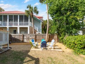 a yard with chairs and a house with a fence at The Flying Pigs Cottage in Tybee Island