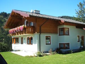 dom z balkonem z kwiatami w obiekcie Ferienwohnung Mützengruß w mieście Filzmoos
