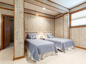 two beds in a room with wooden walls at Sea Gull Ocean Villa in Tybee Island