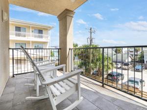 Un balcón con un banco y vista a una calle. en Silver Seas 203, en Tybee Island