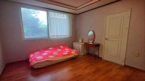 a bedroom with a bed and a mirror and a window at The Red Brick Grove in Wonju +9 photos
