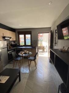 a kitchen and dining room with a table and chairs at A Casiña de Tivo in Fisterra +15 photos