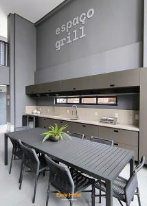 a kitchen with a black table and chairs at Simple Smart Residence - By EasyHost in Tambaú