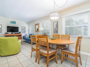 a dining room and living room with a table and chairs at Salty Pause in Tybee Island +17 photos
