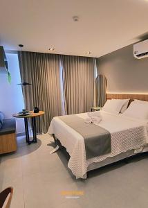 a bedroom with a large bed and a table at Simple Smart Residence - By EasyHost in Tambaú +36 photos