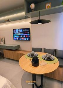 a table in a living room with a tv at Simple Smart Residence - By EasyHost in Tambaú