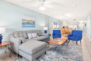 a living room with a couch and blue chairs at Sandpiper 302 in Tybee Island