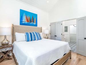 a bedroom with a large white bed with blue pillows at Sail Away in Tybee Island +61 photos