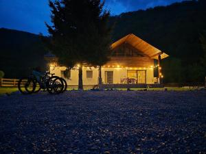 a house with bikes parked in front of it at night at Artizan Chalet in Topliţa