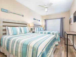 une chambre avec deux lits et un ventilateur de plafond dans l'établissement Sandpiper 205, à Tybee Island