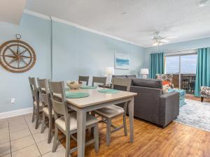 a dining room and living room with a table and chairs at Sandpiper 203 in Tybee Island