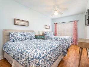 a bedroom with two beds and a ceiling fan at Sandpiper 203 in Tybee Island