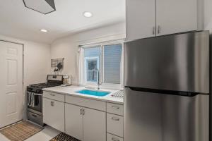 a kitchen with a stainless steel refrigerator and a sink at Stylish Apt in Walker's Point in Milwaukee