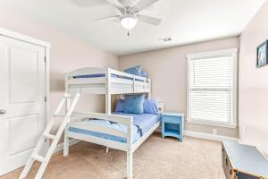 a bedroom with a bunk bed and a ceiling fan at Peach Coral in Tybee Island