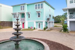 a water fountain in front of a blue house at Peach Coral in Tybee Island