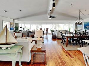 a living room with white furniture and a dining room at Oceanside Unit A in Tybee Island