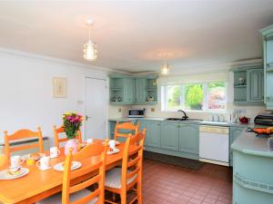 a kitchen with blue cabinets and a wooden table at 4 bed in Ousby 80541 in Ousby